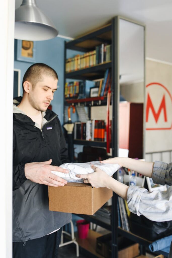 pexels-photo-4440790 Courier delivering a package in a home setting, showcasing logistic services.